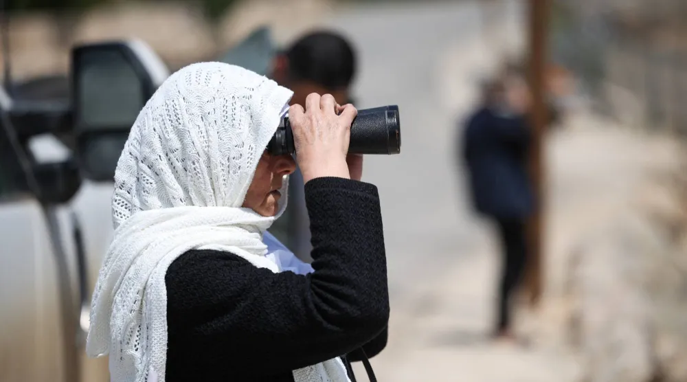 سيدة درزية من الجولان المحتل تنظر عبر الحدود باتجاه سوريا (رويترز)