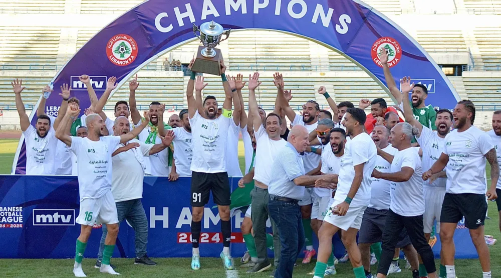لاعبو الأنصار لحظة تتويجهم باللقب (الشرق الأوسط)