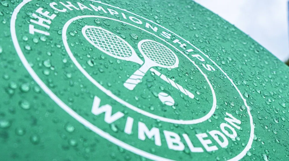 FILED - 29 June 2022, United Kingdom, London: Raindrops and the tournament logo can be seen on an umbrella during the Wimbledon Championships at the All England Lawn Tennis and Croquet Club. Photo: Frank Molter/dpa