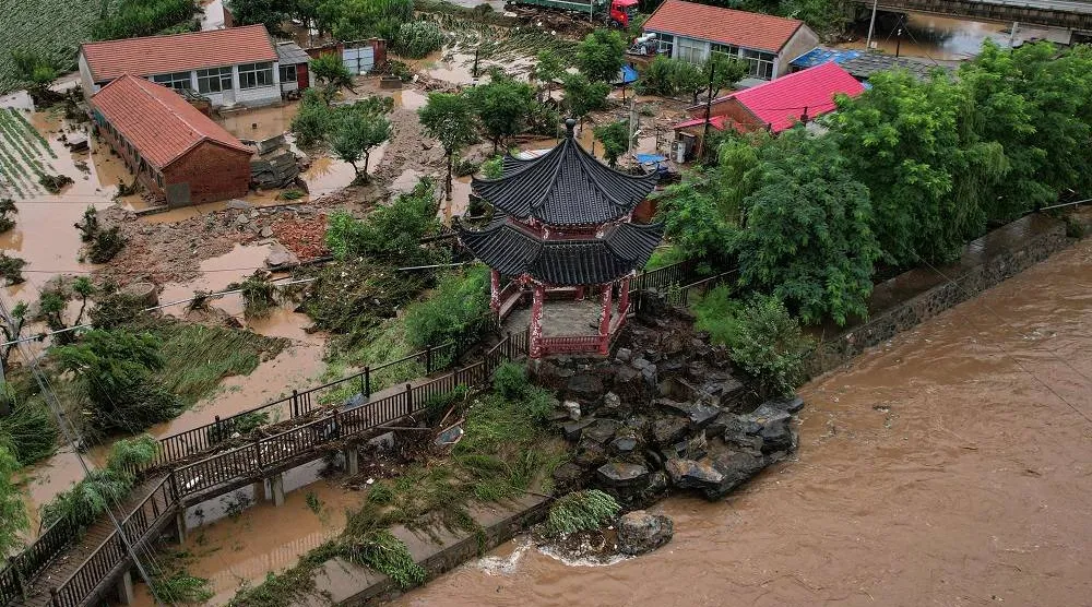 An aerial view shows damaged buildings after heavy rains at Xin'anzhuang village, in Miyun district, on the outskirts of Beijing on July 28, 2025. (AFP)