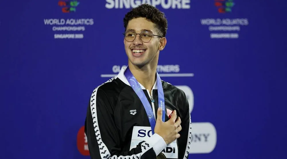  Swimming - World Aquatics Championships - Men 1500m Freestyle - World Aquatics Championships Arena, Singapore - August 3, 2025 Gold medalist Tunisia's Ahmed Jaouadi celebrates on the podium. (Reuters)