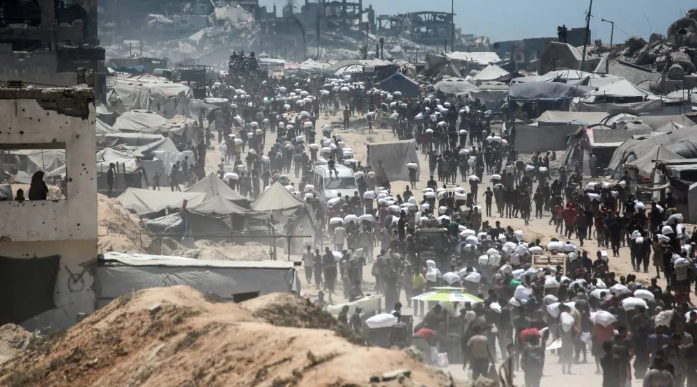 فلسطينيون يحملون أكياس دقيق حصلوا عليها من شاحنات مساعدات دخلت غزة عبر معبر زيكيم في جباليا شمال قطاع غزة (أ.ف.ب)