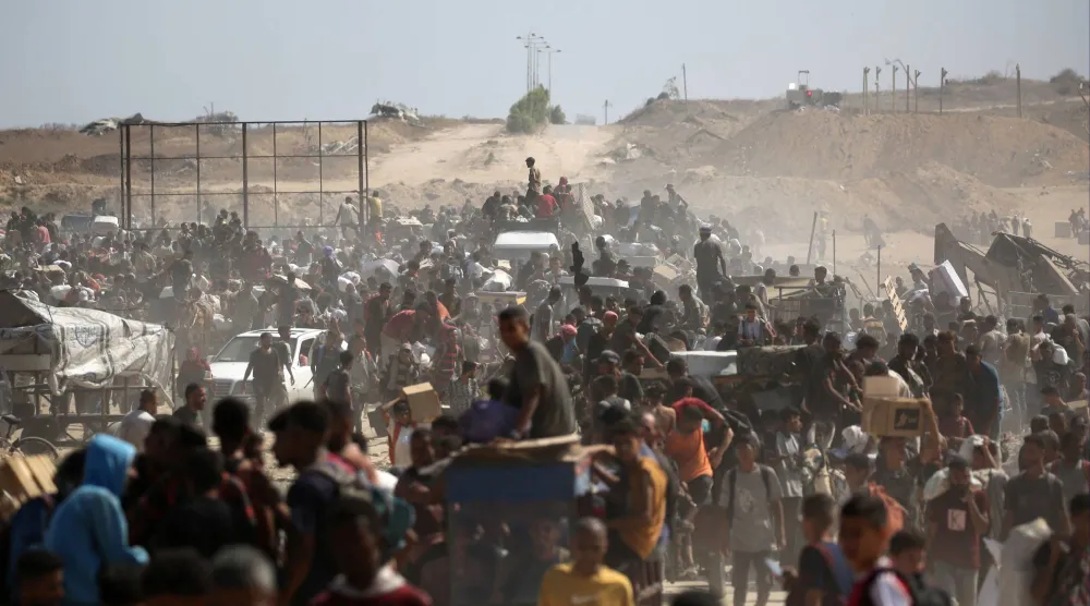 فلسطينيون يحملون مواد إغاثة حصلوا عليها من «مؤسسة غزة الإنسانية» في نتساريم وسط قطاع غزة أمس (أ.ف.ب)