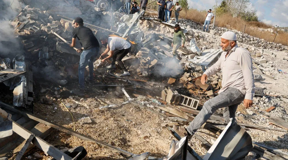 فلسطيني يتفقد مبنى هُدم خلال هجوم للقوات الإسرائيلية في قباطية قرب جنين بالضفة الغربية (رويترز)