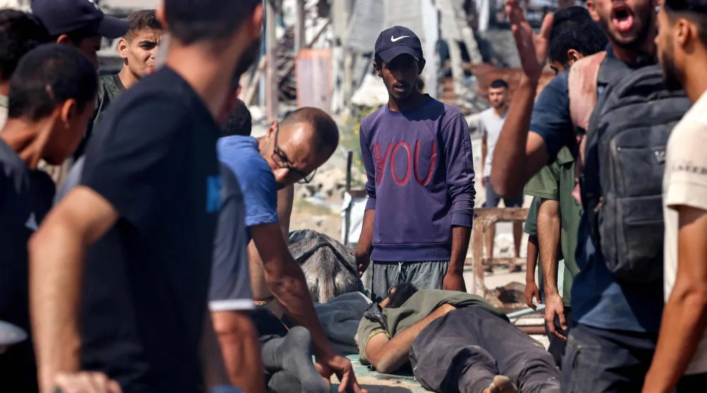 فلسطينيون يتجمعون حول جثث ضحايا استهداف إسرائيلي لمنتظري المساعدات في وسط قطاع غزة (أ.ف.ب)