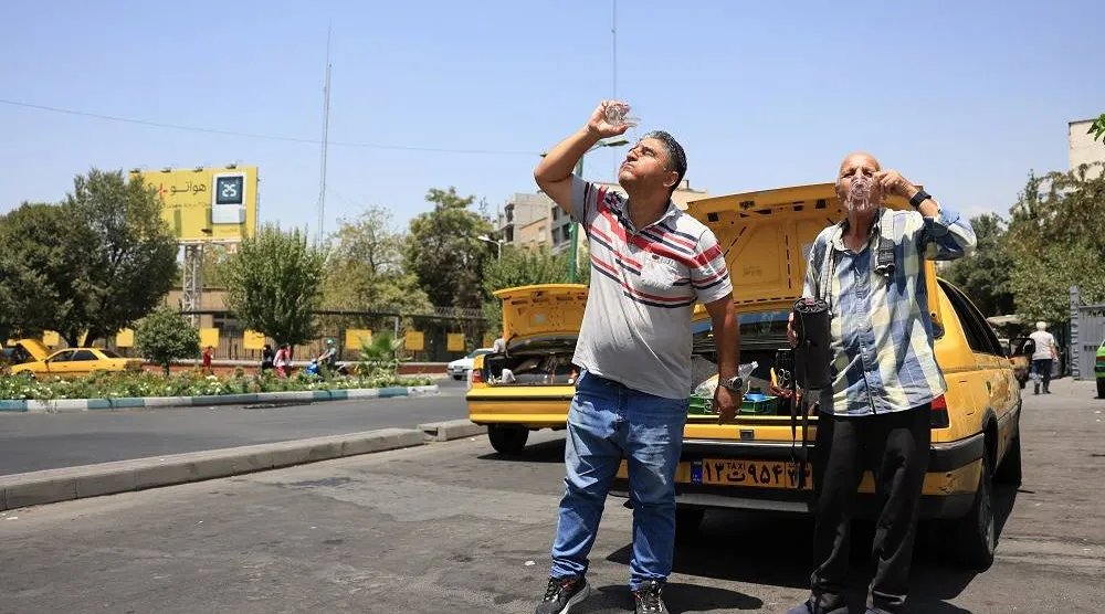 21 July 2025, Iran, Tehran: Two cab drivers cool off during a heatwave in the Iranian capital. (dpa)