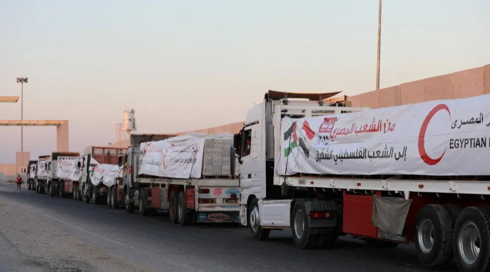 شاحنات من الهلال الأحمر المصري تحمل مساعدات متجهة لقطاع غزة عند معبر رفح في لقطة بُثت يوم الأحد (رويترز)