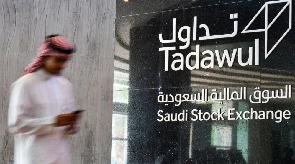 مستثمر يمر بجوار مبنى «السوق المالية السعودية»... (أ.ف.ب)