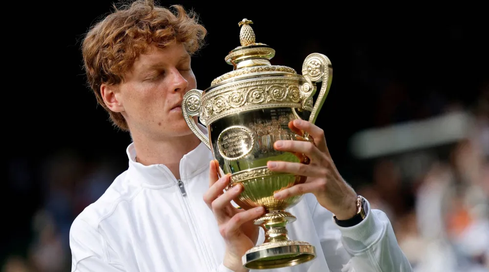 FILE PHOTO: Italy's Jannik Sinner celebrates with the trophy after winning the Wimbledon men's final against Spain's Carlos Alcaraz in London, July 13, 2025. REUTERS/Stephanie Lecocq/File Photo