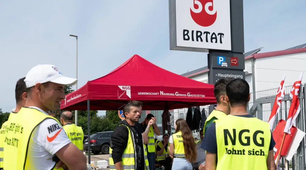 06 August 2025, Baden-Württemberg, Murr: Strikers stand in front of the Birtat factory. The NGG trade union is demanding a collective agreement for the employees of kebab skewer manufacturer Birtat. Photo: Markus Lenhardt/dpa