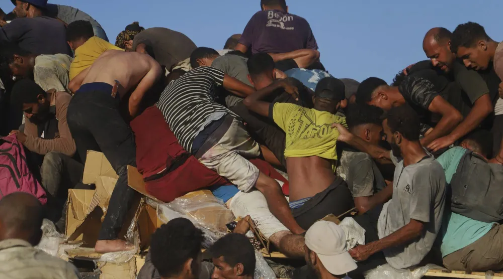 فلسطينون في قطاع غزة يتدافعون للحصول على معونات غذائية في ظل أوضاع مأساوية (أ.ب)