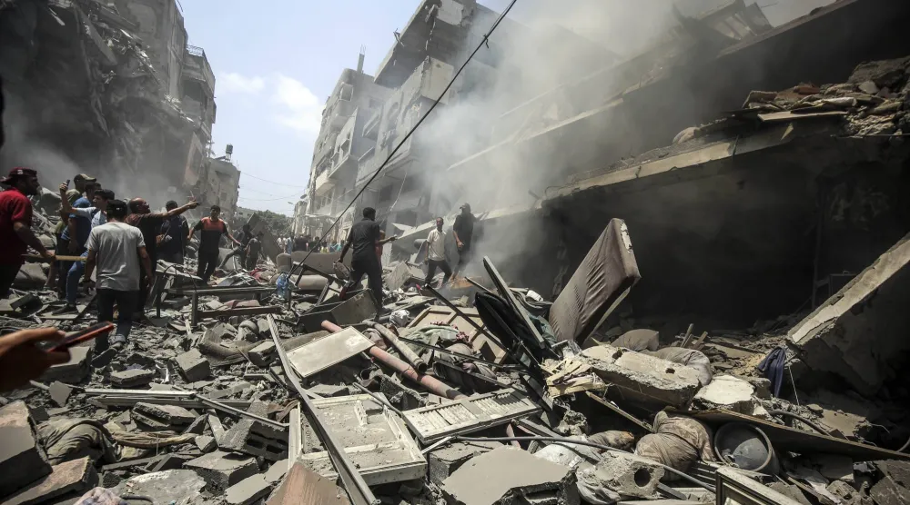 فلسطينيون يتفقدون الدمار الذي خلفته غارة إسرائيلية على حي الزيتون بجنوب مدينة غزة (د.ب.أ)