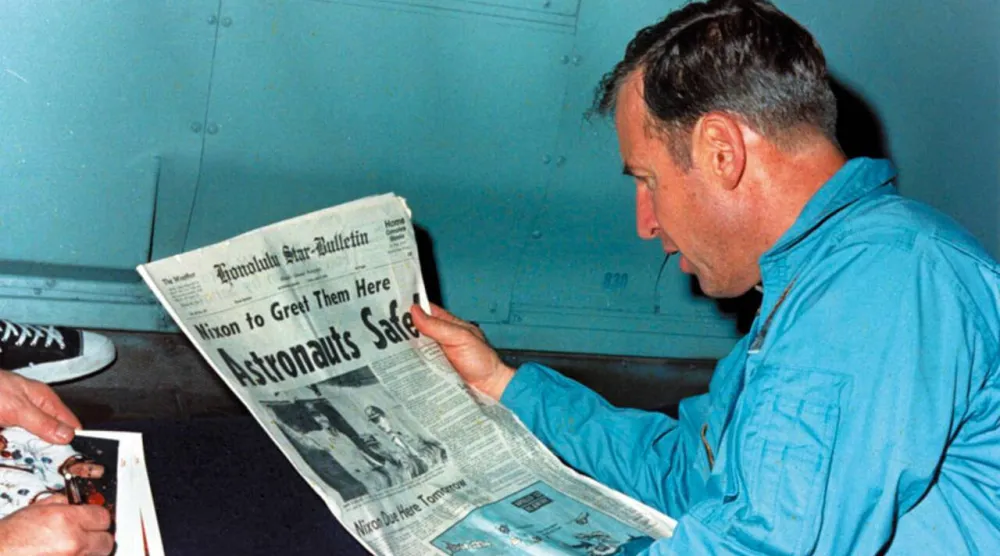 Astronaut Jim Lovell reads the news after his crew returned safely to Earth from a failed Moon mission in 1970. Handout / NASA/AFP/File
