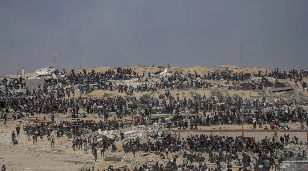 نازحون فلسطينيون ينتظرون شاحنات مساعدات قرب نقطة توزيع أغذية في زيكيم شمال قطاع غزة (إ.ب.أ)
