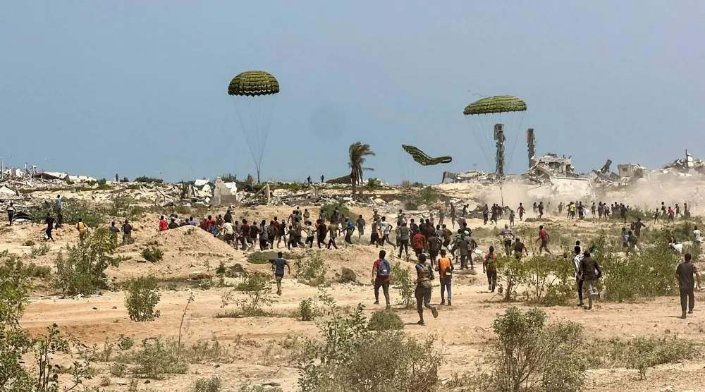 فلسطينيون يهرعون لأماكن سقوط حزم مساعدات من الجو... وقتل الفتى الفلسطيني محمد عيد في المكان نفسه بعدما سقطت حزمة مساعدات فوقه وسط غزة (رويترز) 