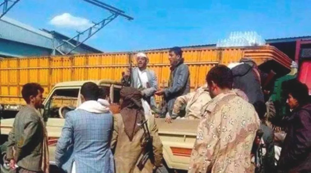 مسلحون حوثيون أمام معمل لتعبئة المياه في صنعاء (فيسبوك)

