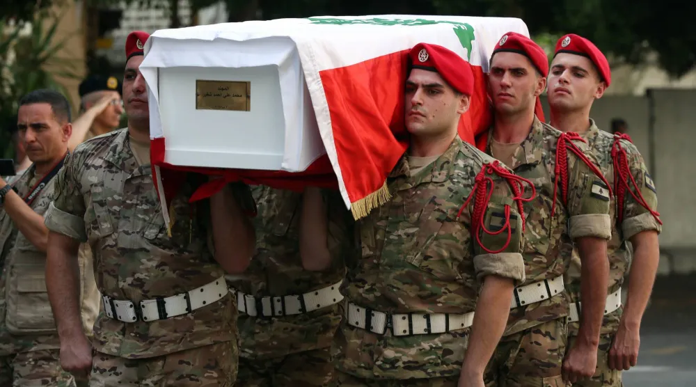 جنود لبنانيون يحملون نعش أحد رفاقهم الستة الذين قتلوا في مخزن ل"حزب الله" خلال مراسيم تشييعهم في بيروت أمس (إ.ب.أ)