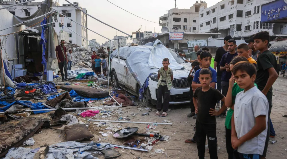 فلسطينيون يعانون أمس خيمة الصحافيين أمام مستشفى الشفاء في مدينة غزة التي استهدفتها ضربة إسرائيلية أوقعت خمسة قتلى (أ.ف.ب)
