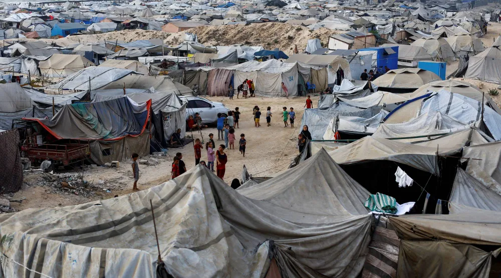 Palestinians, displaced by the Israeli offensive, shelter in a tent camp on a beach amid summer heat in Gaza City, August 12, 2025. REUTERS/Mahmoud Issa