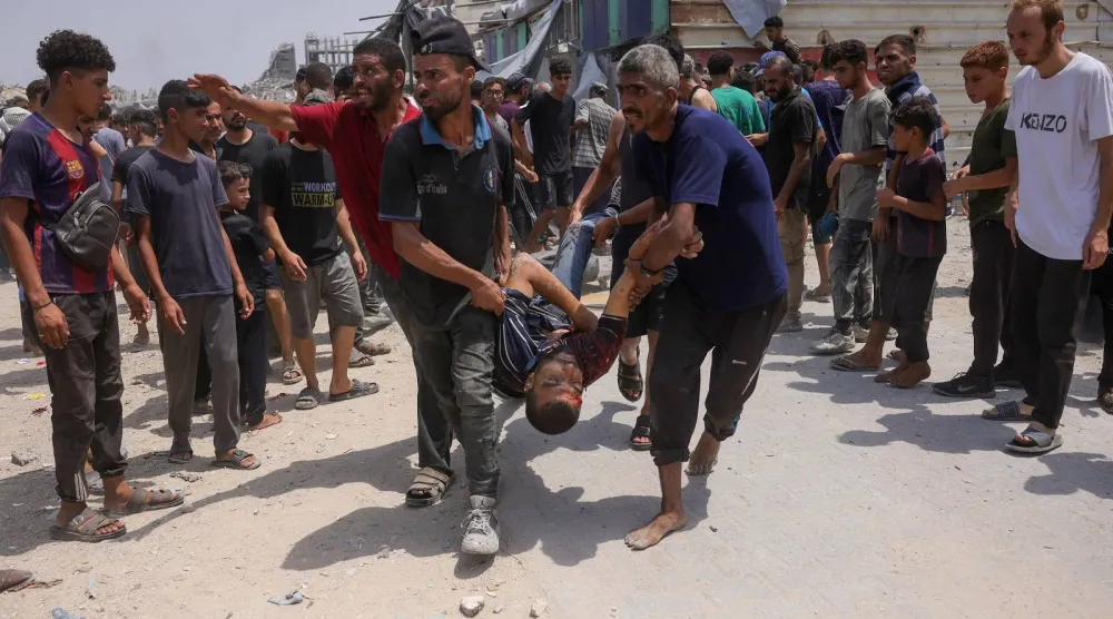 فلسطينيون يحملون ضحايا غارات إسرائيلية في حي الصفطاوي غرب جباليا شمال غزة (أ ف ب)