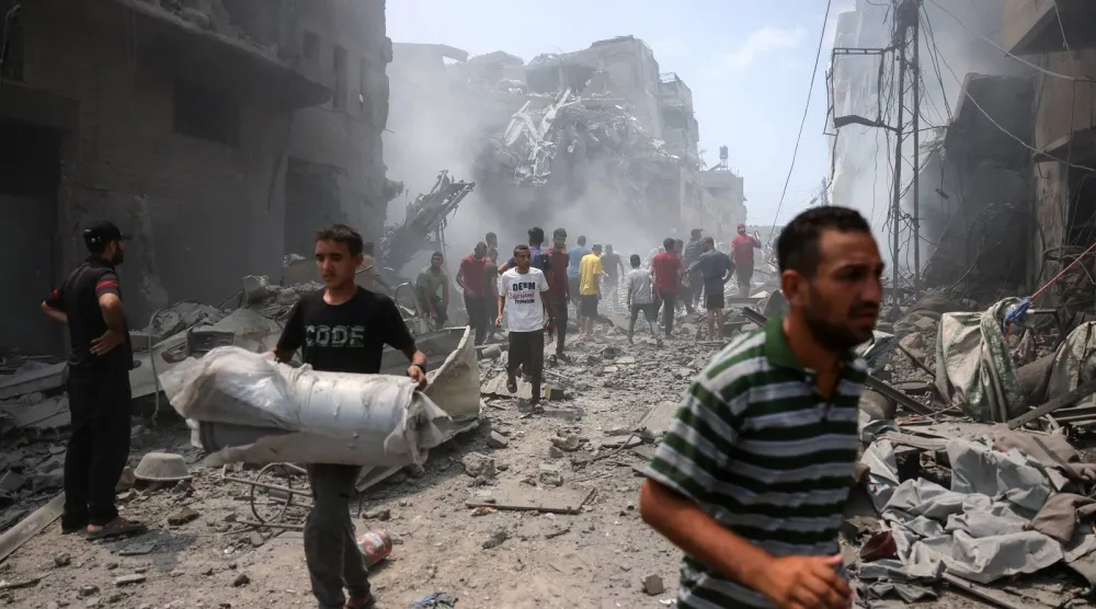 فلسطينيون يتفقدون الدمار الذي خلفته غارة إسرائيلية استهدفت حي الزيتون جنوب مدينة غزة (أ.ف.ب)