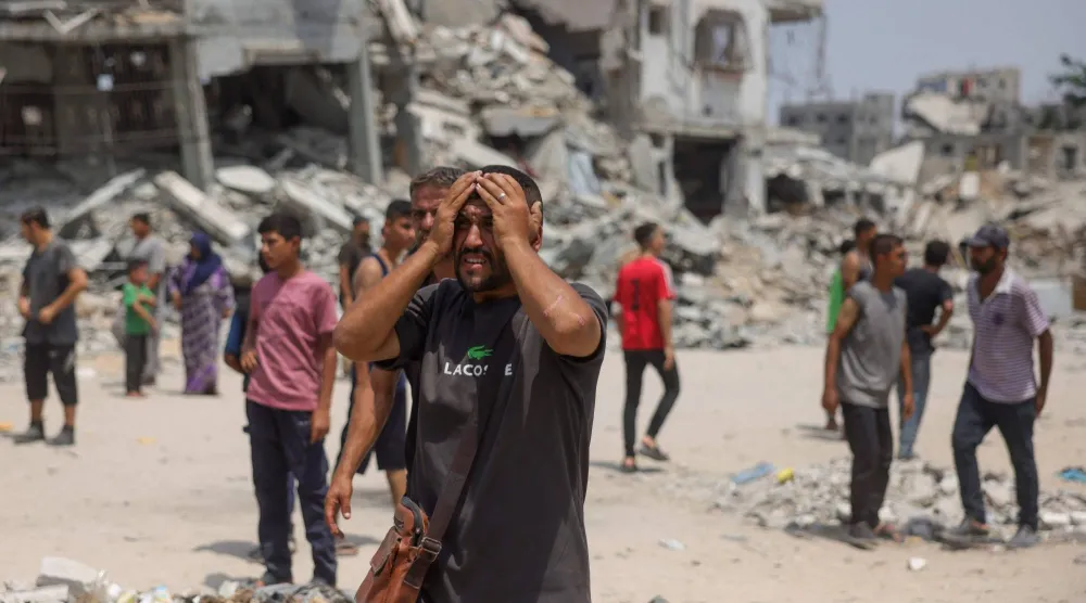 فلسطيني يبكي بينما ينقل المسعفون ضحايا الغارات الإسرائيلية في جباليا شمال قطاع غزة يوم الأربعاء (أ.ف.ب)