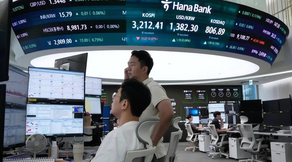 متداولون أمام شاشة تعرض مؤشر «كوسبي» وسعر صرف الدولار الأميركي في مقر بنك «هانا بسيول» (أ.ب)
