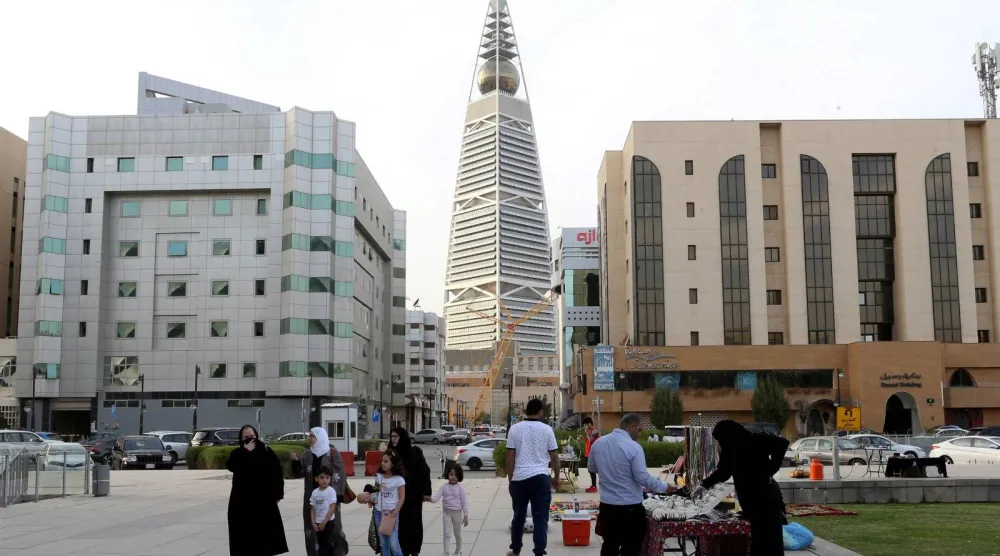 اشخاص يسيرون في أحد أحياء العاصمة الرياض (أ.ف.ب)