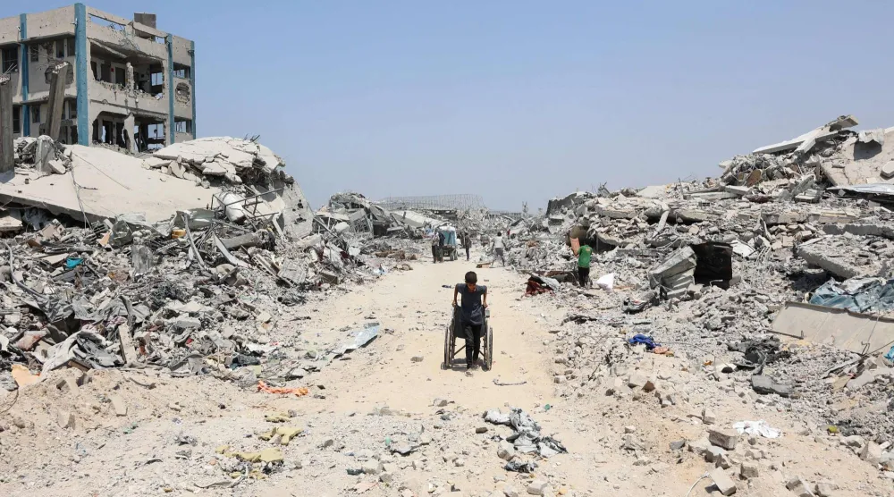 صبي فلسطيني يمر عبر مبانٍ مدمرة نتيجة الحرب في مدينة غزة (أ.ف.ب)