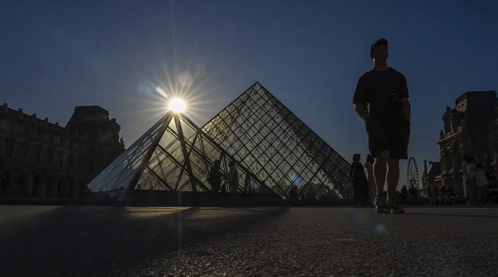 Tourists walk near the Louvre in Paris, Sunday, Aug. 17, 2025. (AP)