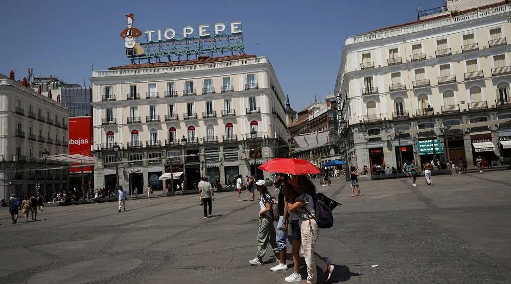People protect themselves with an umbrella during a heatwave in Madrid, Spain, August 5, 2025. (Reuters)