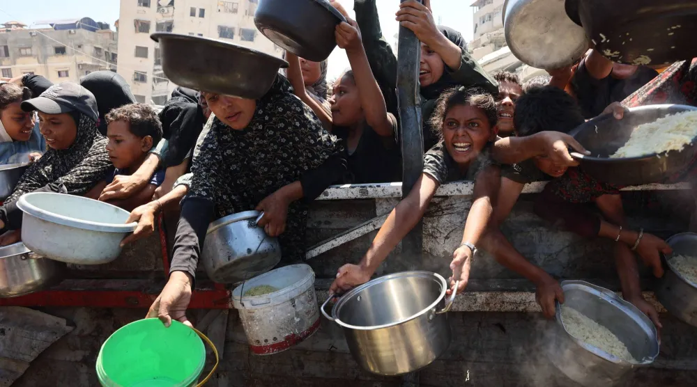 فلسطينيون ينتظرون الحصول على طعام في مدينة غزة اليوم السبت (أ.ف.ب)
