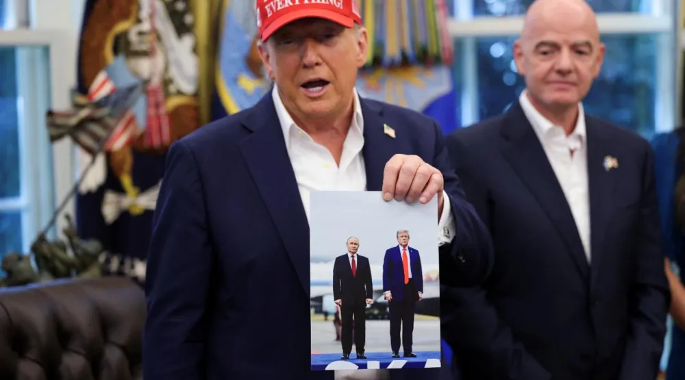 Oval Ofis'te ABD Başkanı Donald Trump, Rusya Devlet Başkanı Vladimir Putin'in kendisine hediye ettiğini söylediği fotoğrafı gösterdi (Reuters)