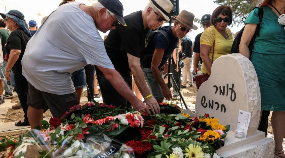 Ailesi ve arkadaşları, 7 Ekim 2023'teki saldırıda hayatını kaybeden bir İsraillinin cenazesinin, İsrail'in güneyindeki Kibbutz Kfar Aza'daki evinin yakınına nakledilmesinin ve yeniden gömülmesinin ardından anma törenine katıldı. (Reuters)