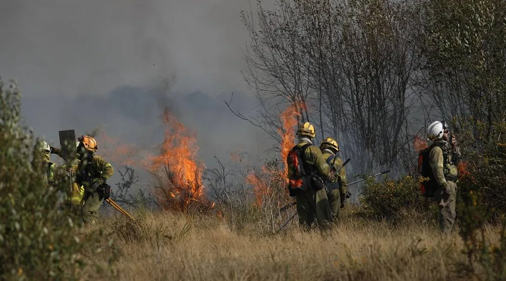 Firefighters work to extinguish a new forest fire that started in the Sil Canyon and is spreading to Lornis, Lugo, North Spain, 19 September 2025. (EPA) 