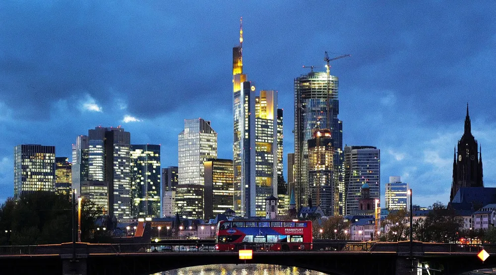 الحي المالي بفرانكفورت يظهر في الخلفية وحافلة ذات طابقين تمر في الأمام (رويترز)