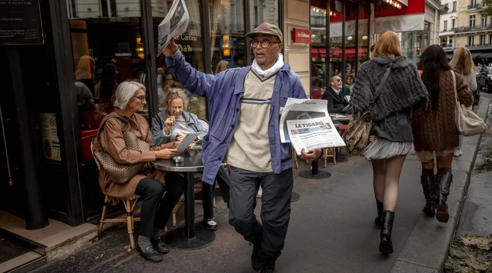 علي أكبر يبيع نسخ الصحف في الحي اللاتيني بباريس في 16 سبتمبر 2025 (أ.ف.ب)