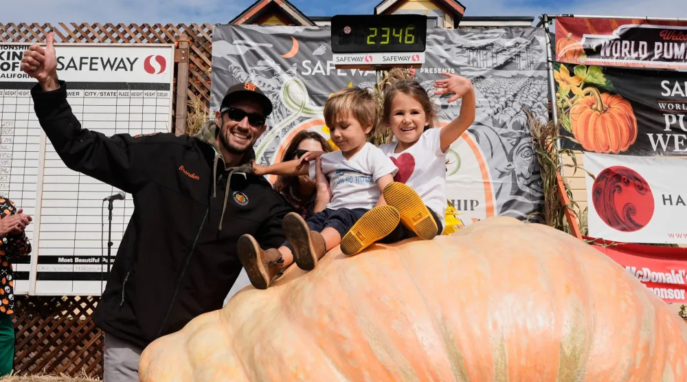 داوسون يحتفل مع طفليه فوق اليقطين العملاق (أ.ب)