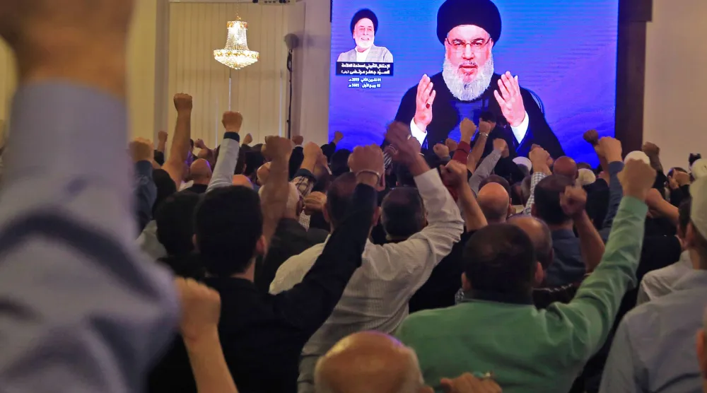 أنصار «حزب الله» يشاهدون حسن نصر الله وهو يُلقي خطاباً عبر شاشة عملاقة داخل مسجد في الضاحية الجنوبية بيروت في نوفمبر 2019 (أ.ف.ب)