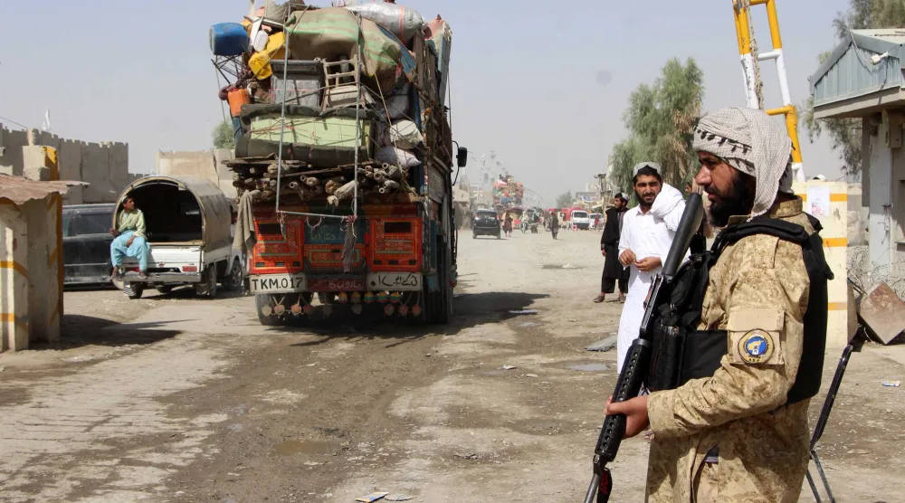 عناصر أمن أفغان يراقبون عودة مواطنيهم إلى إقليم سبين بولداك عقب فتح المعبر الحدودي في قندهار - 19 أكتوبر (إ.ب.أ)