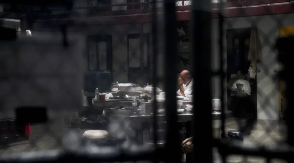 يقرأ كتاباً في غرفة عامة للسجناء في غوانتنامو (نيويورك تايمز)