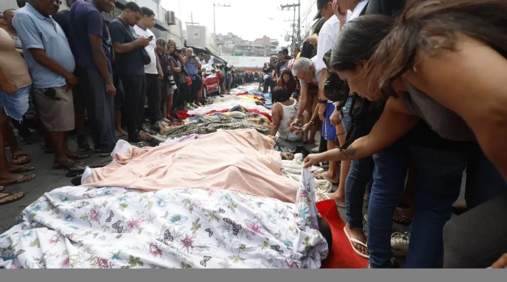 Brezilya vatandaşları dün Rio de Janeiro'daki bir sokakta toplanan cesetlere bakıyor (EPA)