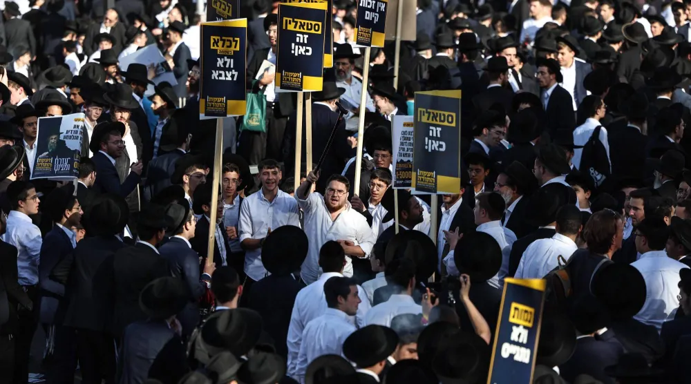 يهود حريديم يحملون لافتات خلال احتجاج ضد التجنيد بالجيش الإسرائيلي في القدس 30 أكتوبر 2025 (أ.ف.ب)
