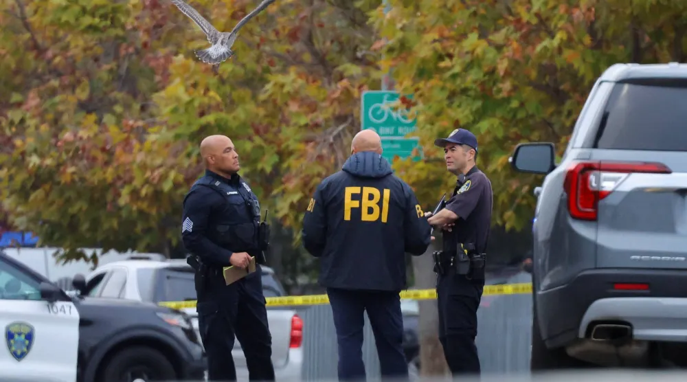 أحد عملاء «مكتب التحقيقات الفيدرالي» يتحدث إلى ضباط إنفاذ القانون في موقع إطلاق نار بكاليفورنيا (رويترز)
