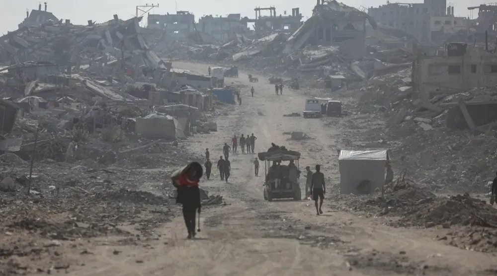 Gazze şehrinin kuzeyindeki es-Saftavi bölgesinde yıkılmış evlerin arasından yürüyen Filistinliler (DPA)