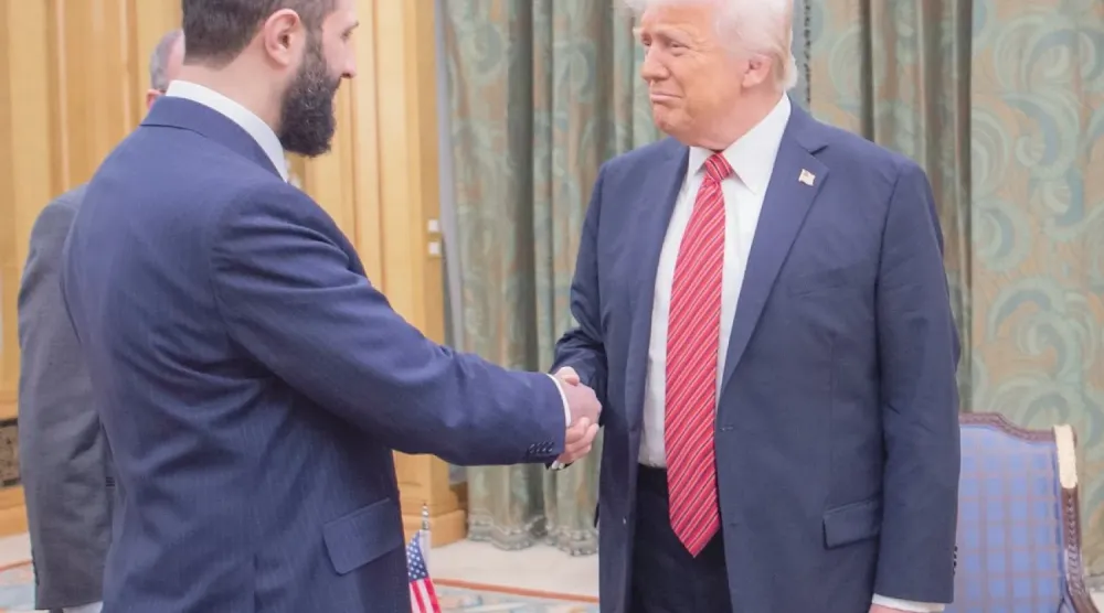 ABD Başkanı Donald Trump, 14 Mayıs'ta Riyad'da Suriye Cumhurbaşkanı Ahmed eş-Şara ile tokalaşırken (AP)