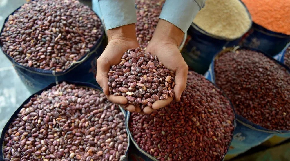  رجل يبيع الفاصوليا الحمراء بسوق جملة في باكستان (إ.ب.أ)