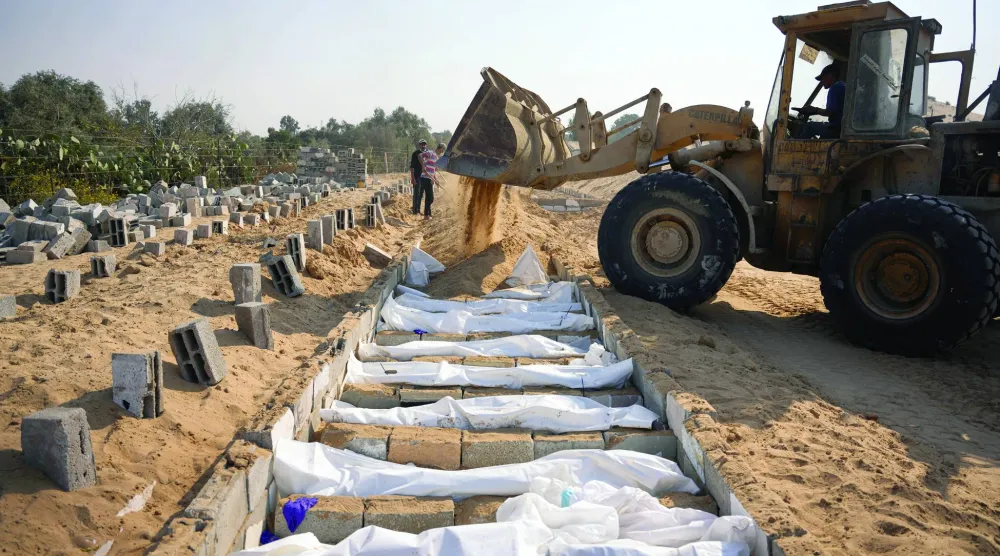 
دفن جثامين فلسطينيين مجهولي الهوية سلمتها إسرائيل في إطار اتفاق وقف النار بدير البلح في قطاع غزة أمس (أ.ب)