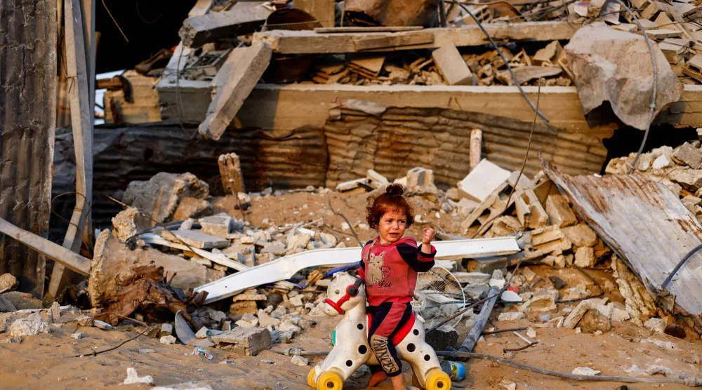 طفلة فلسطينية تلعب وسط أنقاض المباني المدمرة في جباليا بشمال قطاع غزة أمس (رويترز)