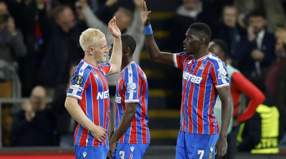 السنغالي إسماعيلا سار يحتفل بتسجيل الهدف الثالث لكريستال بالاس برفقة زميله ويل هيوز (أ.ب).